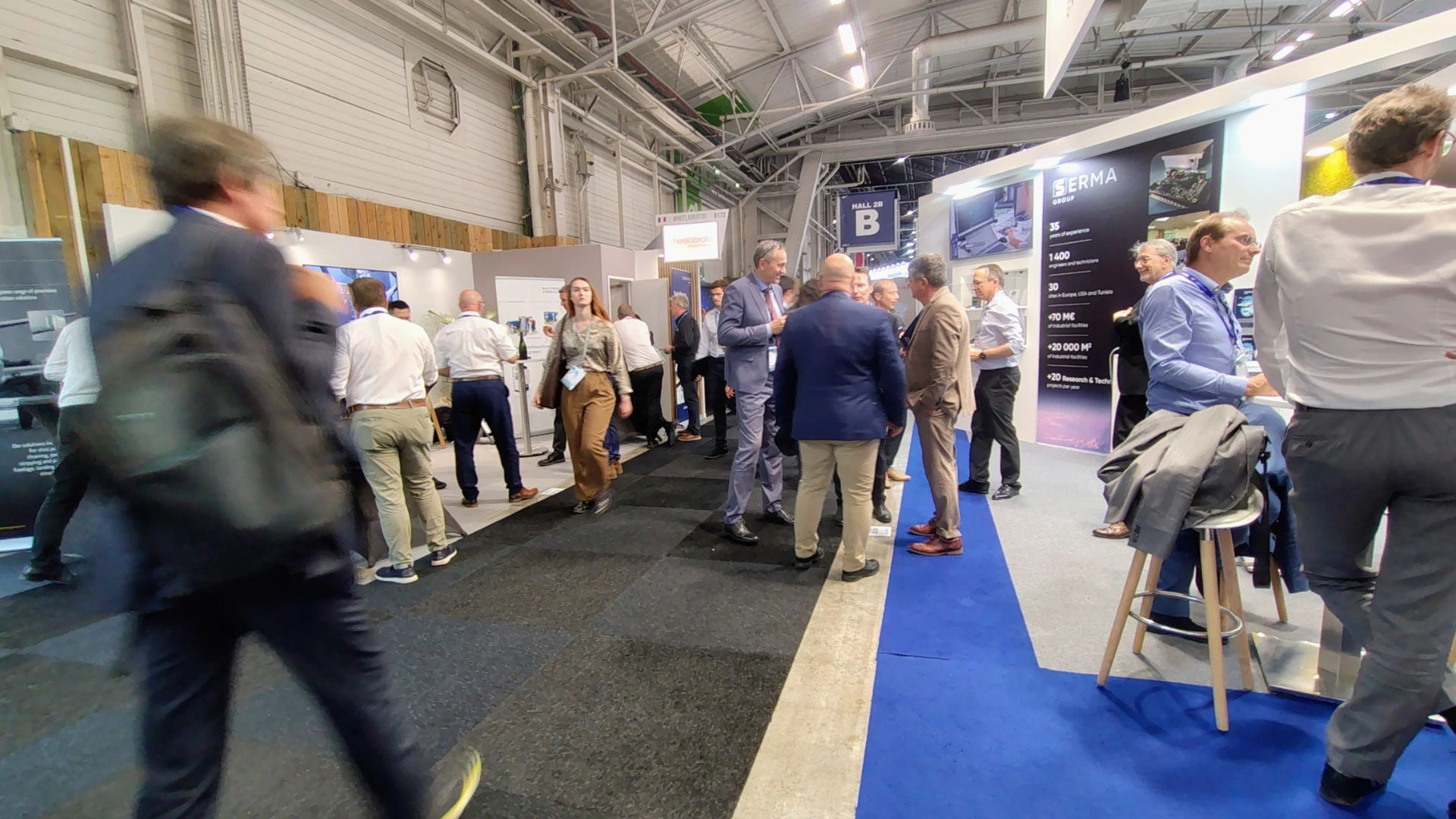 Trade show floor with visitors walking past exhibitor booths, illustrating how visitors filter booths in seconds