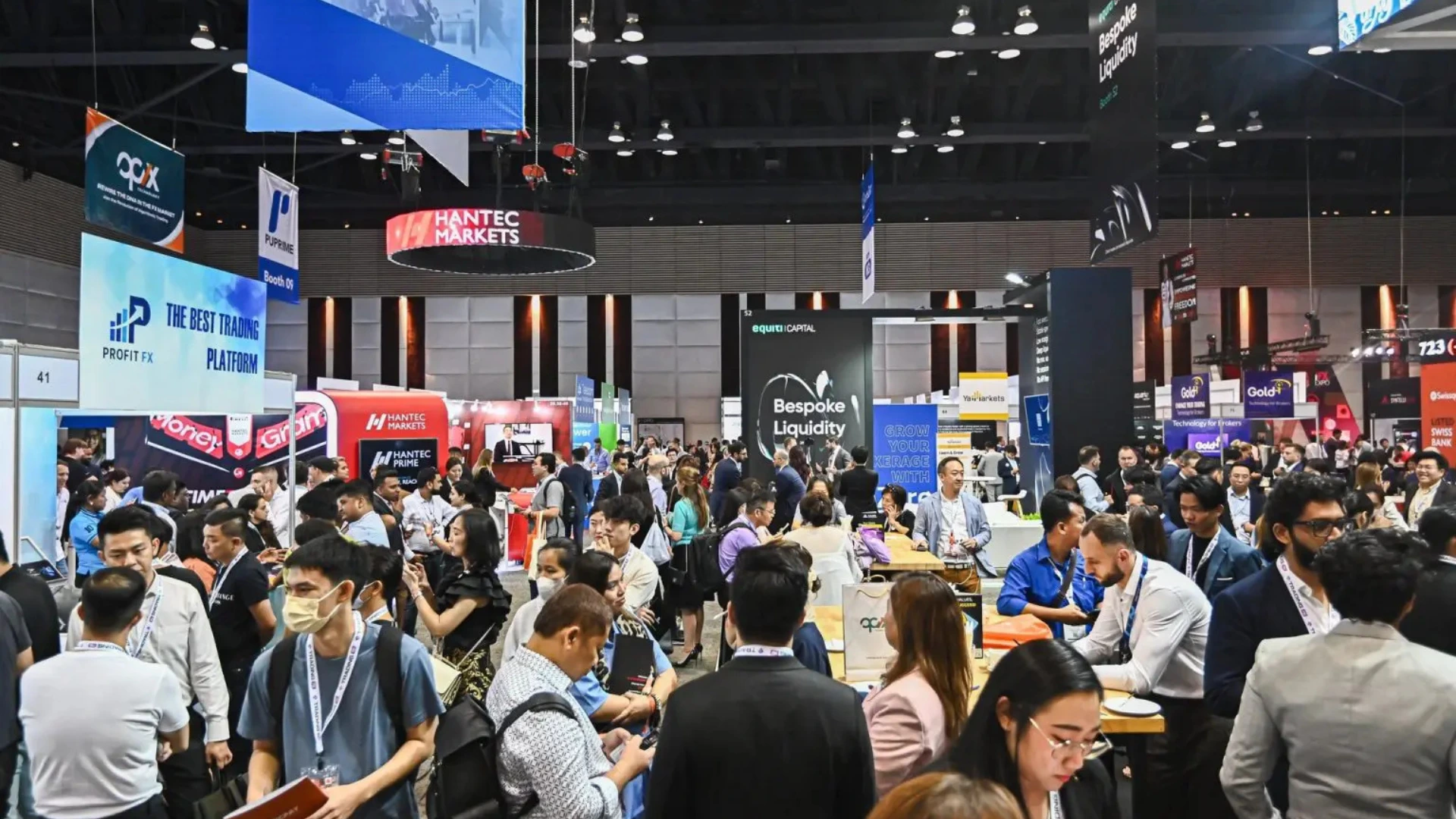 Busy trade show floor with exhibitors and visitors engaged in conversations, illustrating a successful trade show booth in action.